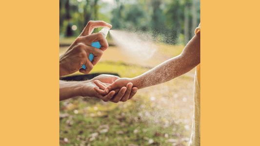 sunscreen being sprayed on child's arm while outside