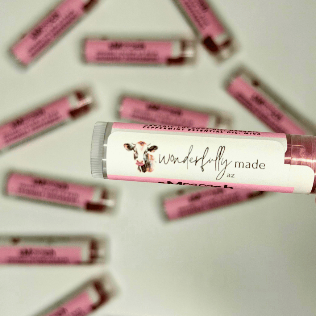 Pink lip balm tubes with 'wonderfully made az' label on a light background