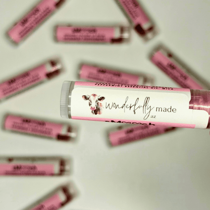Pink lip balm tubes with 'wonderfully made az' label on a light background