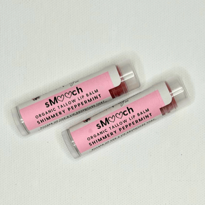 Two organic tallow lip balms with pink packaging on a white background