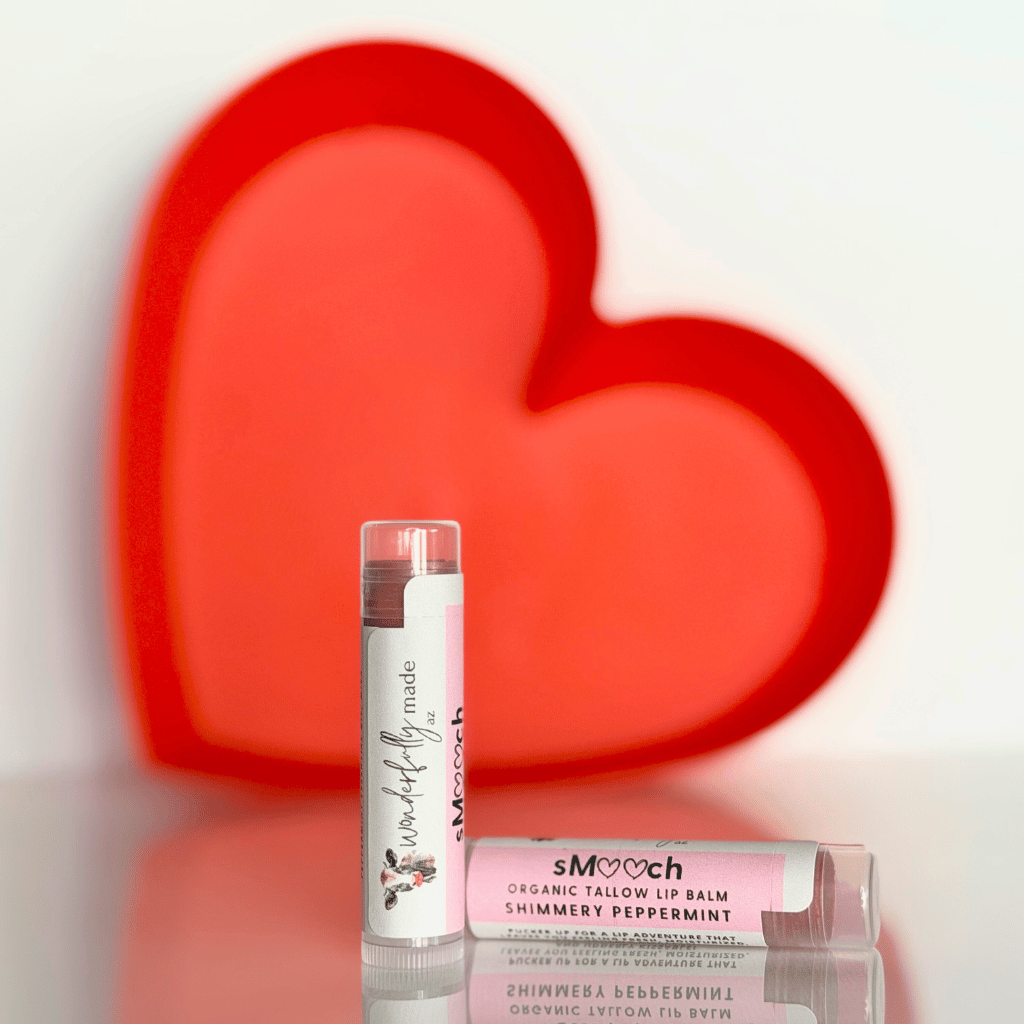 Two lip balms with visible branding against a heart-shaped background