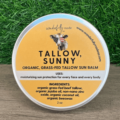 Organic Tallow Sunny sun balm with grass background on wood surface